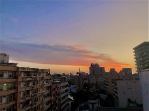 Wide shot of a city skyline showcasing various residential buildings at sunset.