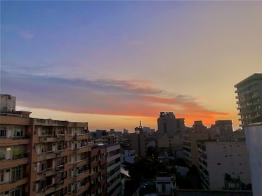 Wide shot of a city skyline showcasing various residential buildings at sunset.