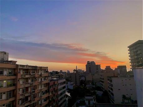 A modern city skyline with residential buildings at sunset.