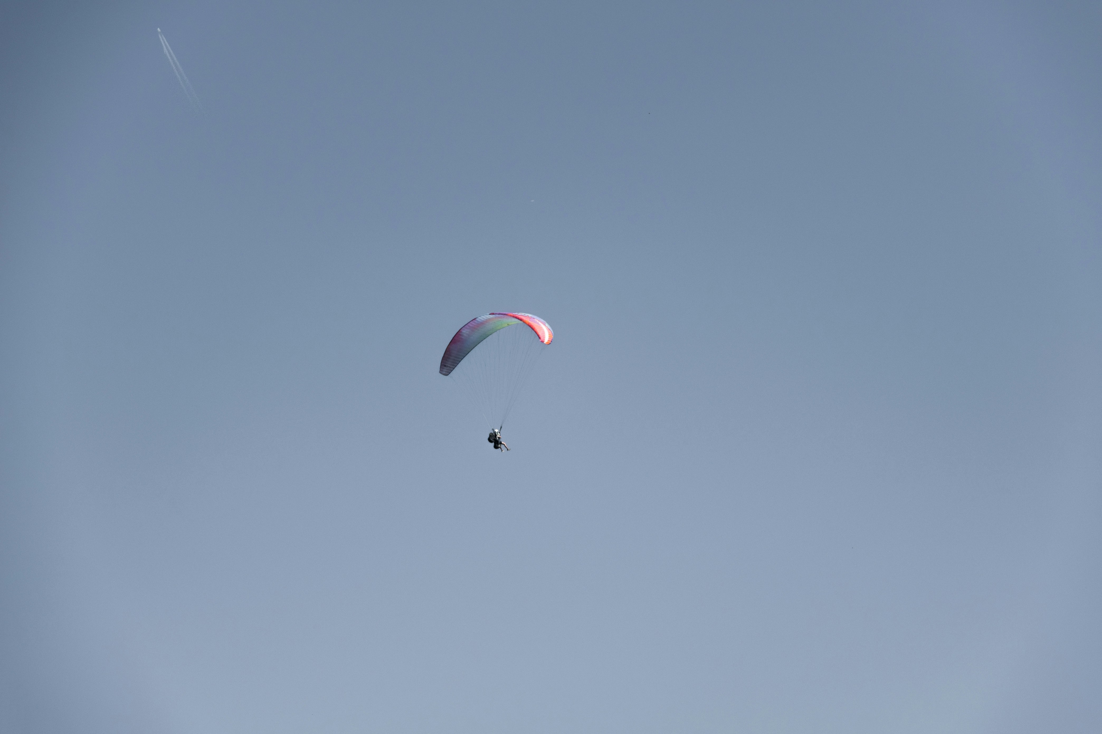 a person in the air with a parachute