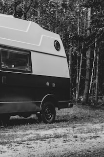 Square image of a vintage Hymer B 544 caravan from 1985, set against a forest backdrop