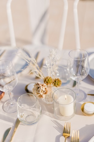Close-up of hands setting a beautifully decorated table with Gather’s rental items.