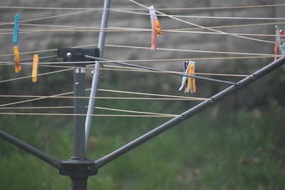 A close-up of stainless steel clothespins on a clothesline.