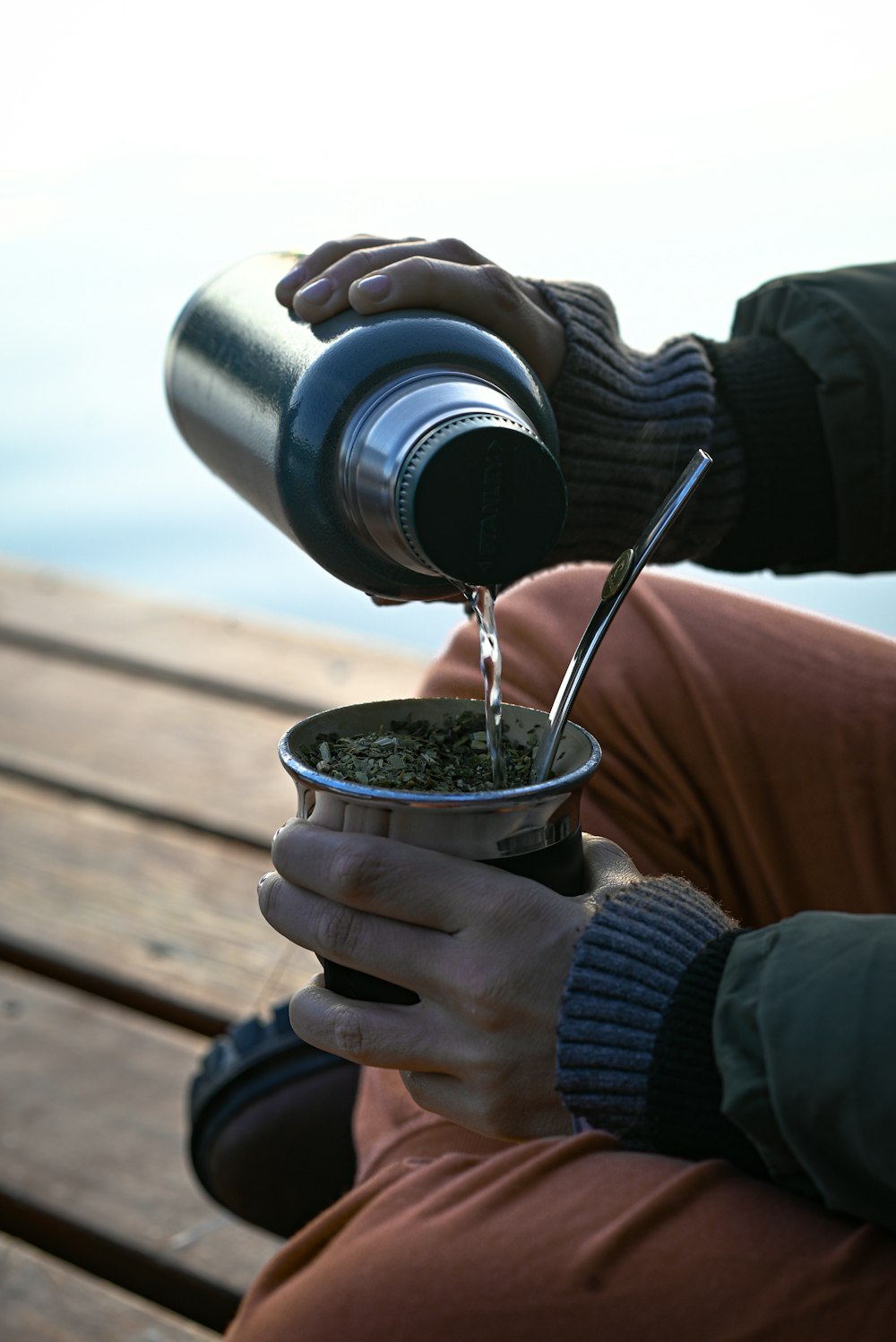 a person pouring a liquid into a cup