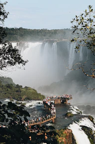 a bridge over a river with a waterfall and trees