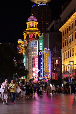Vibrant neon-lit street scene at night with energetic young people dancing and laughing.