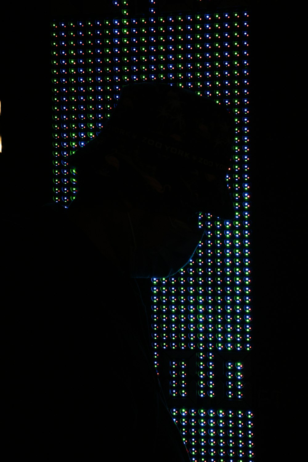 a person's face in a dark room with a large window