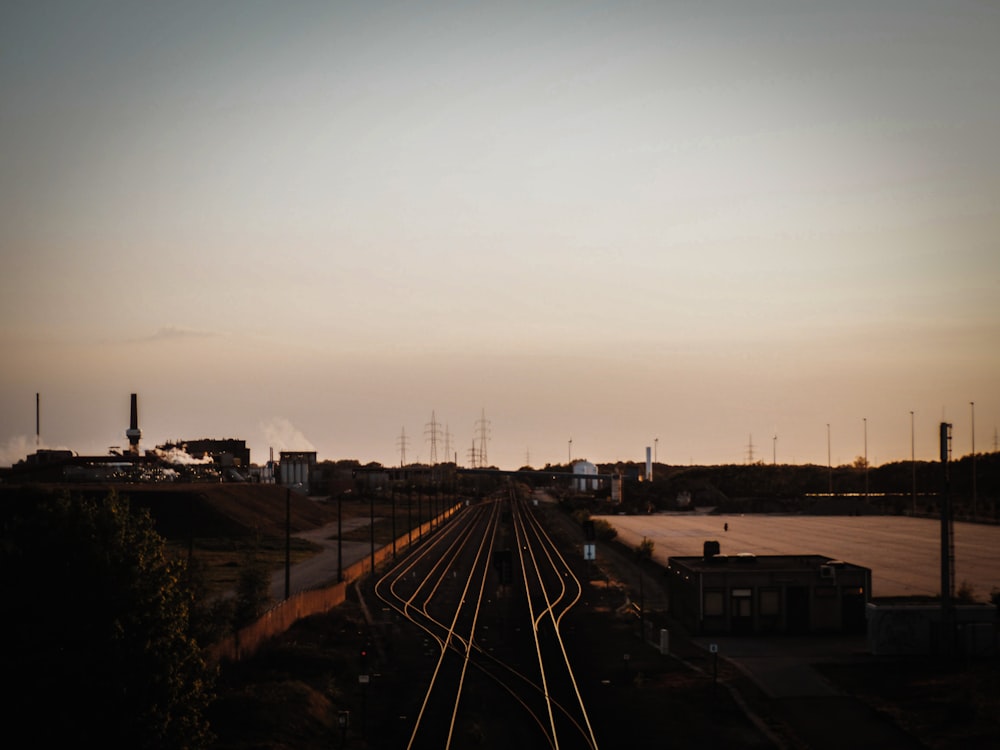 a train track with buildings and power lines on the side