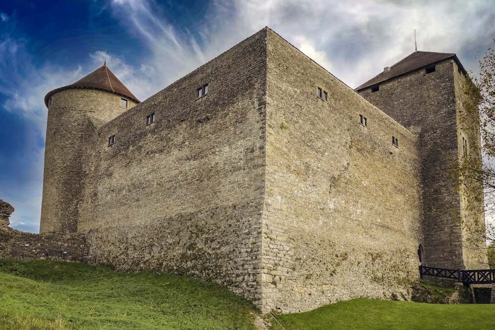 a stone castle with a grass field