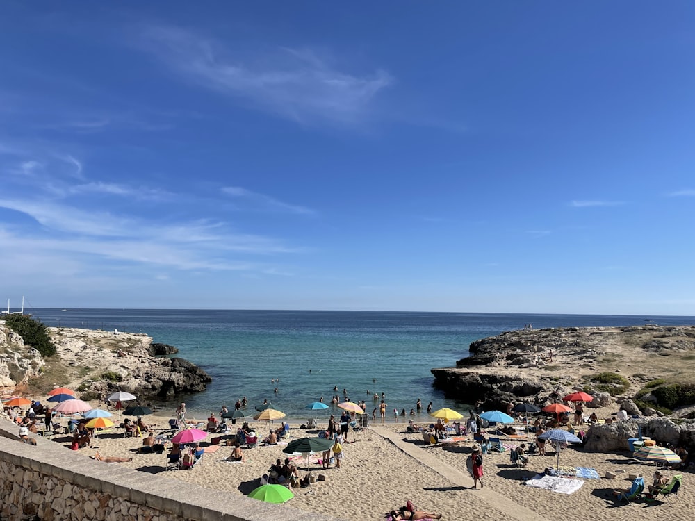 a beach with people and umbrellas