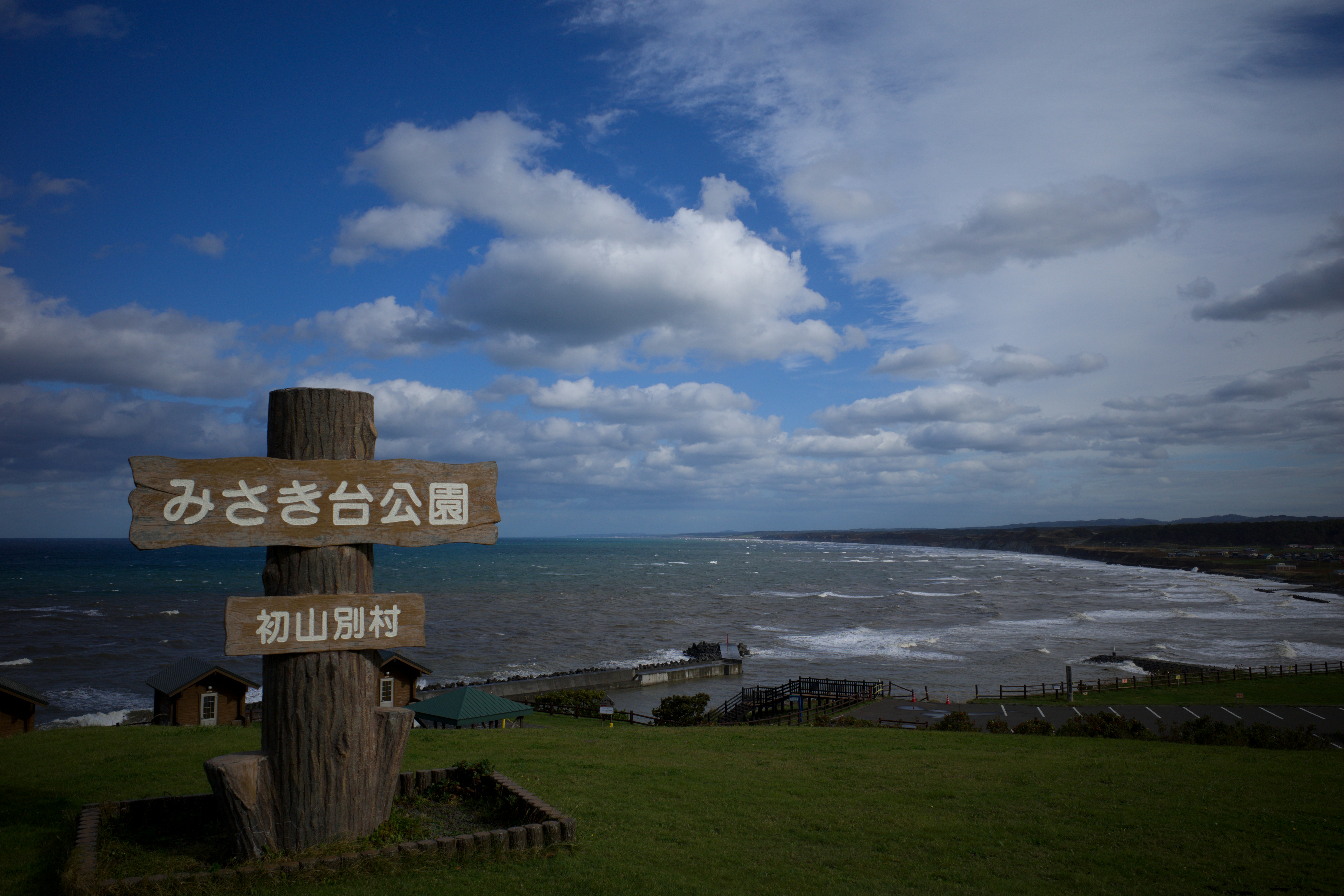 a sign on a post overlooking a beach