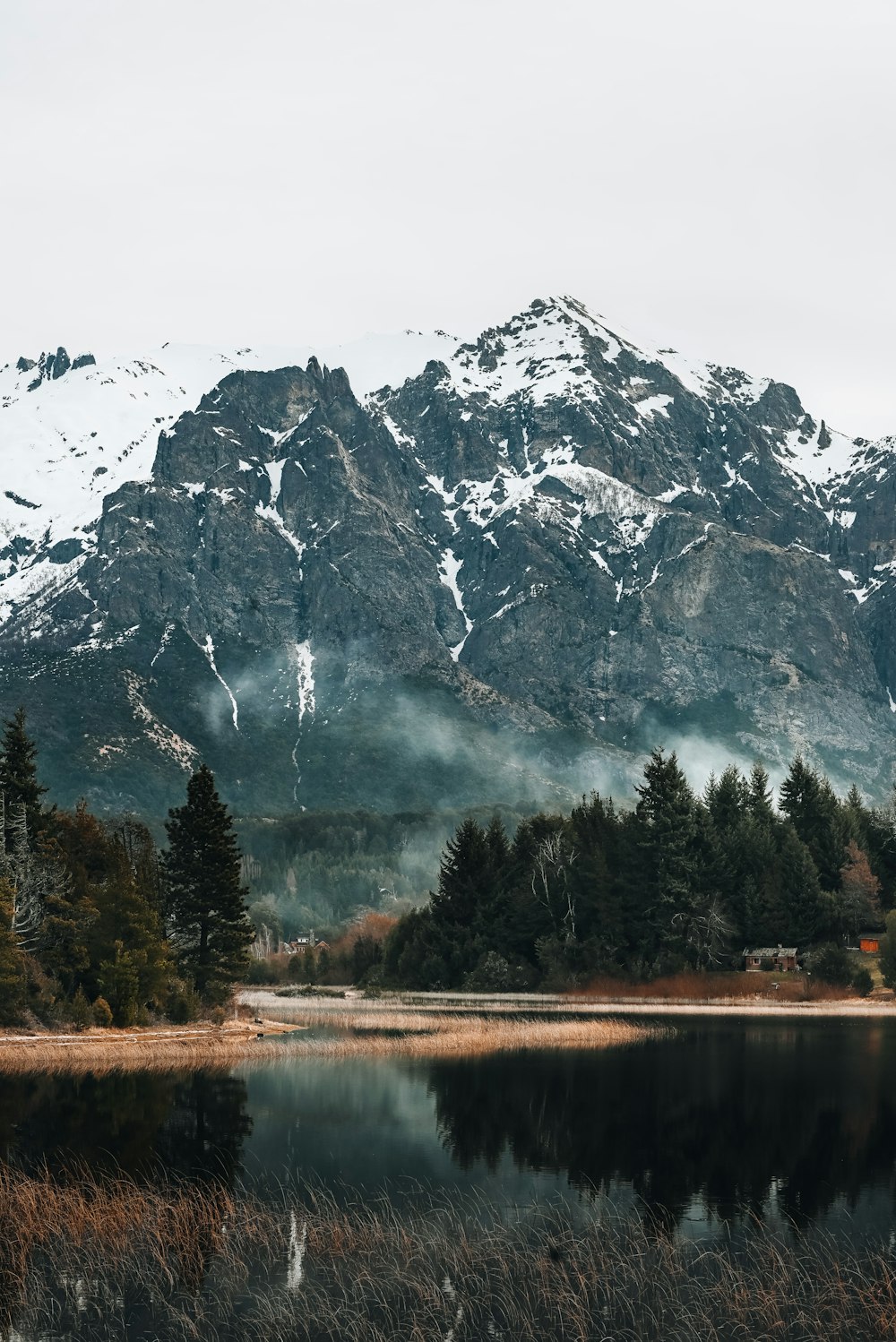 a lake with trees and mountains in the background