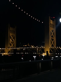 Evening view of a completed bridge illuminated, symbolizing connection and progress.