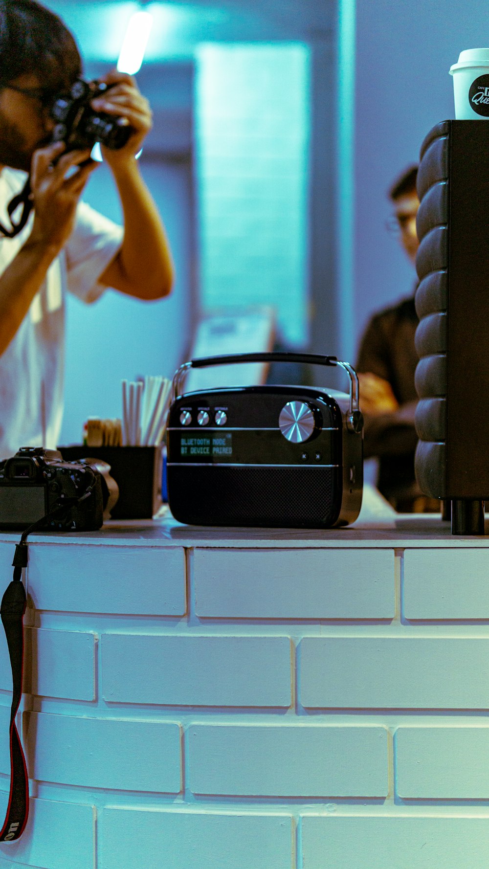 a person taking a picture of a camera on a counter