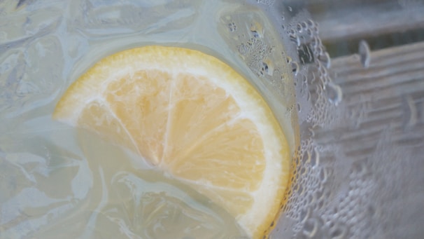Close-up of a fresh lemon slice with droplets of juice sparkling in natural light.