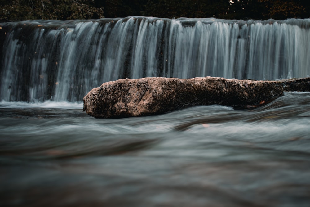 a waterfall with a rock in the foreground