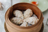 Close-up of steaming hot momos arranged neatly on a traditional bamboo steamer.