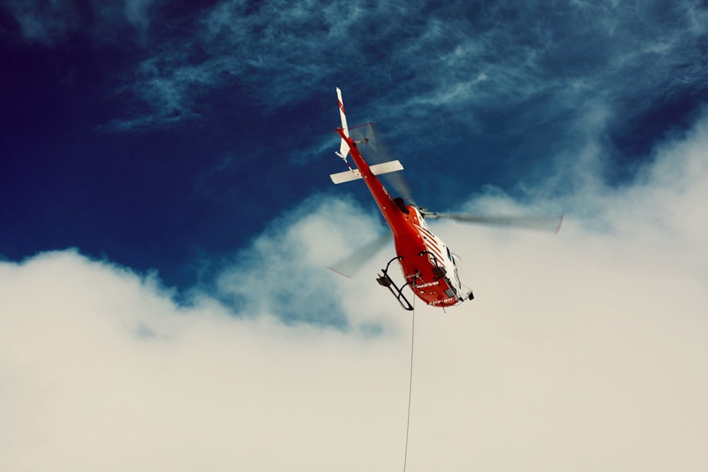 a red and white airplane in the sky