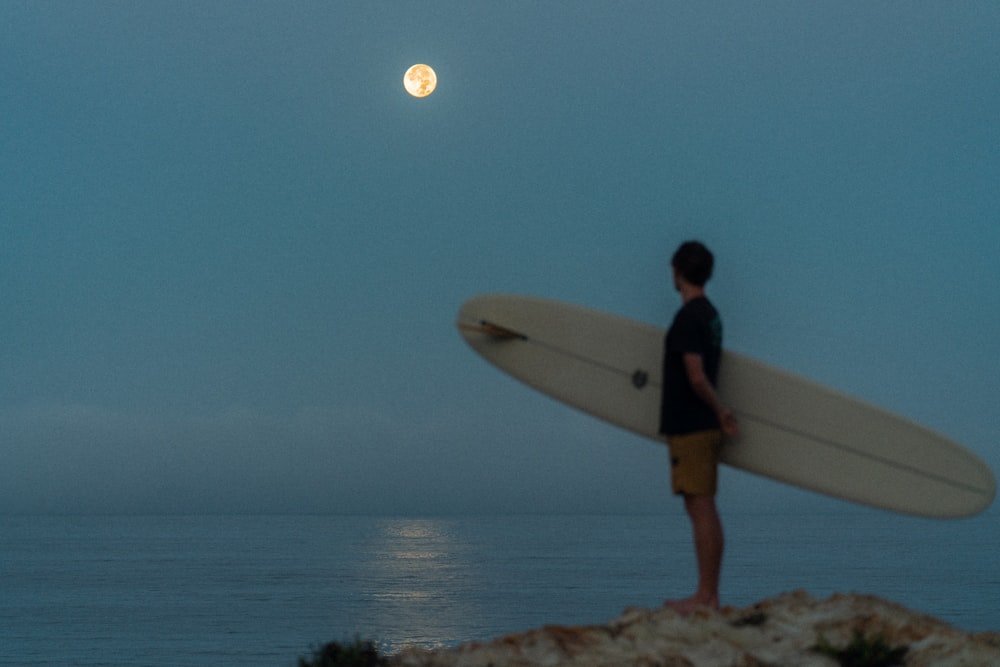 a man carrying a surfboard