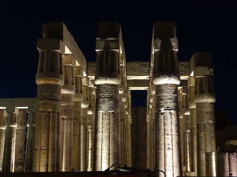 Luxor Temple illuminated at night with colossal statues of Ramesses II