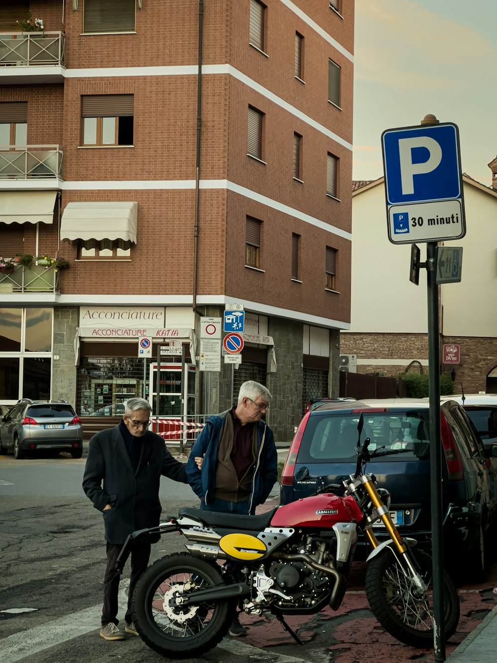 a couple of men standing next to motorcycles on a street