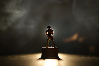 Pop culture icon figure displayed on a sleek pedestal with soft lighting.