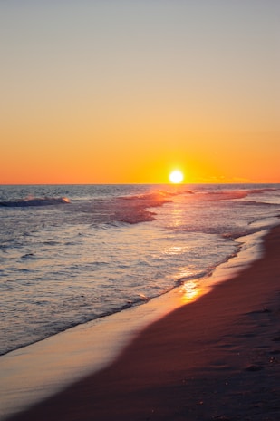 A serene beach sunset reflecting warm earth tones.