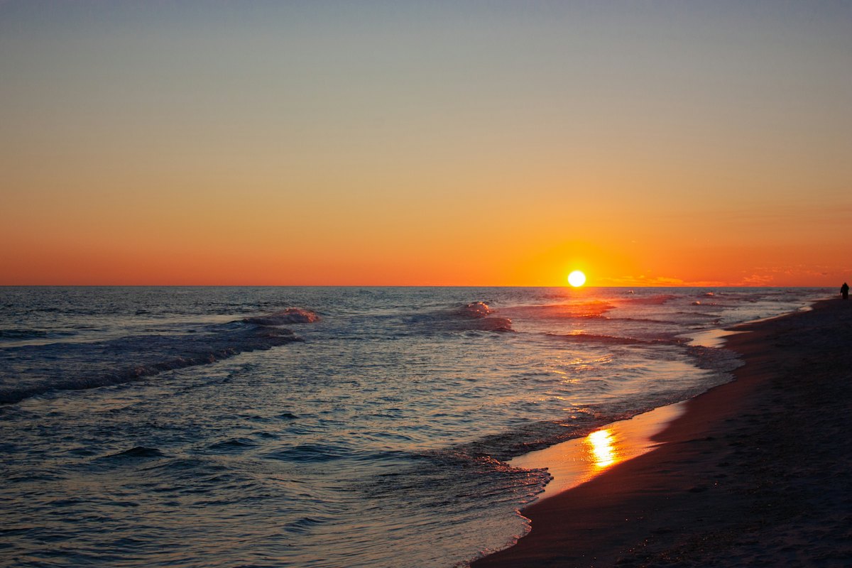 The sun setting over Gulf waves