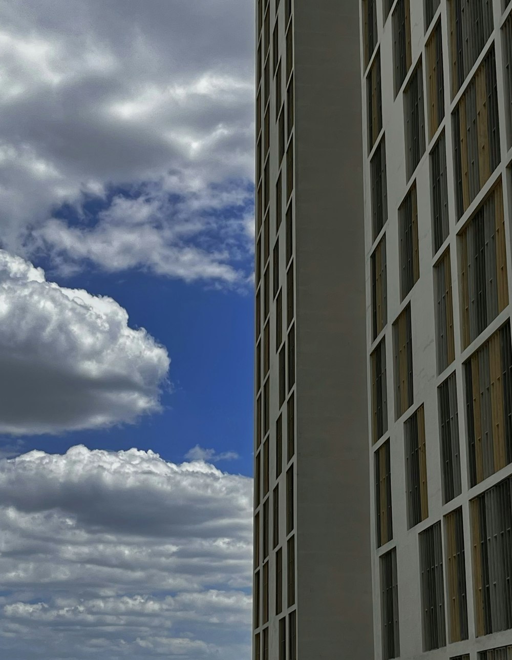 a tall building with clouds in the sky