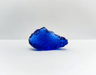 a blue rock on a white surface