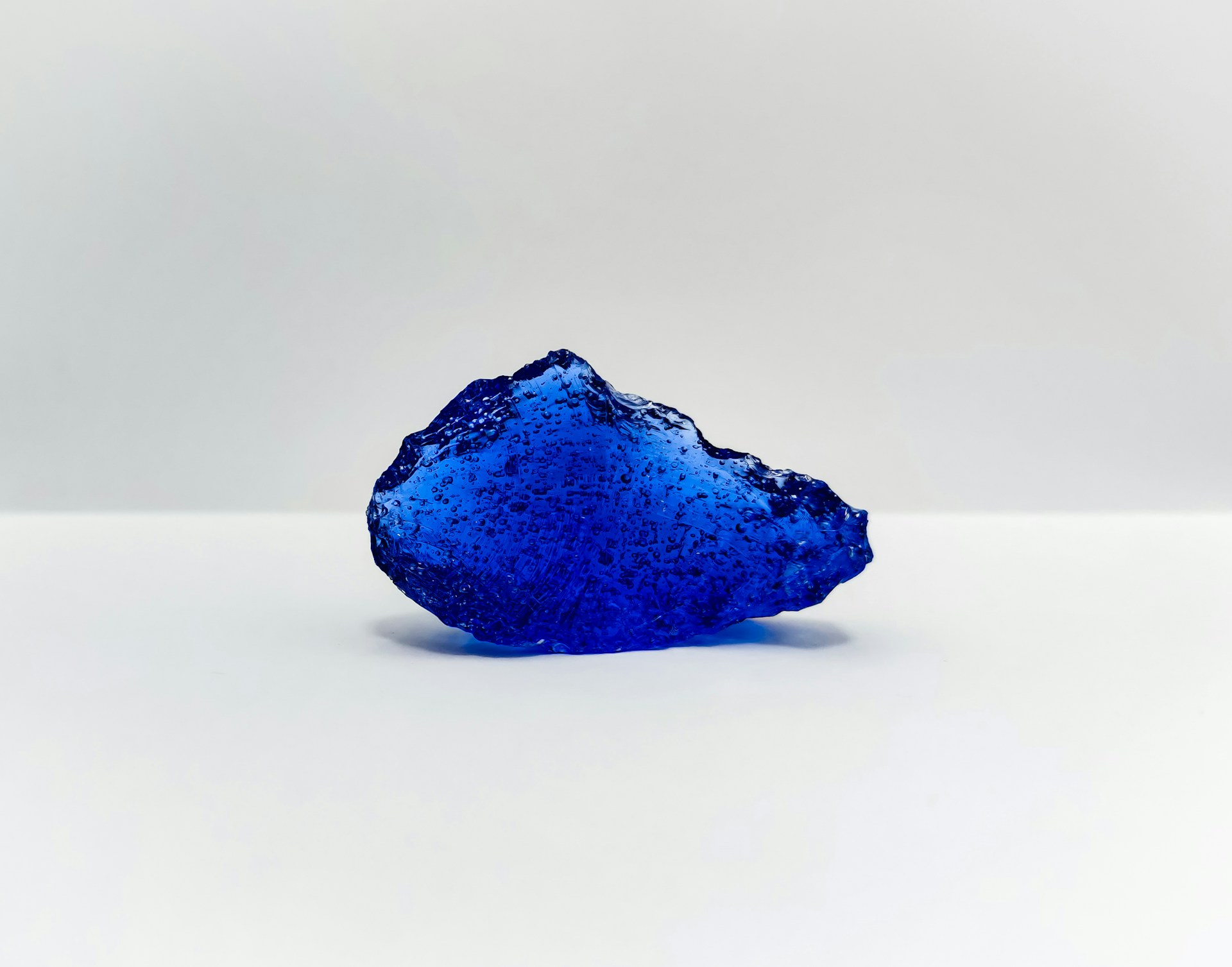 a blue rock on a white surface