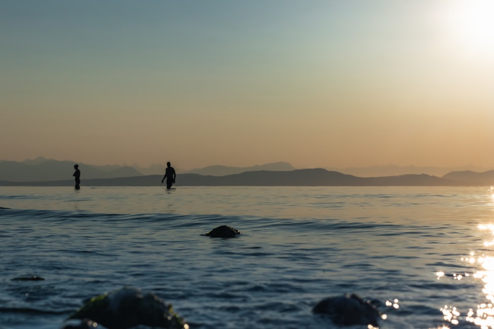 two people standing on a beach