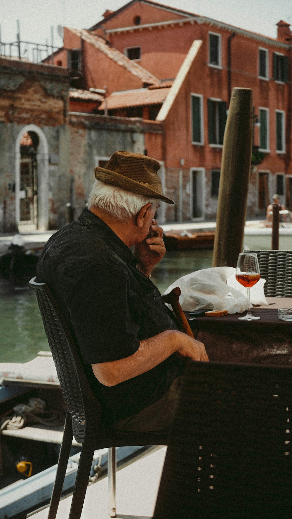 a man sitting at a table with a glass of wine