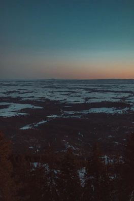 A cinematic landscape showing a desert meeting a snowy Nordic forest, blending two worlds seamlessly.