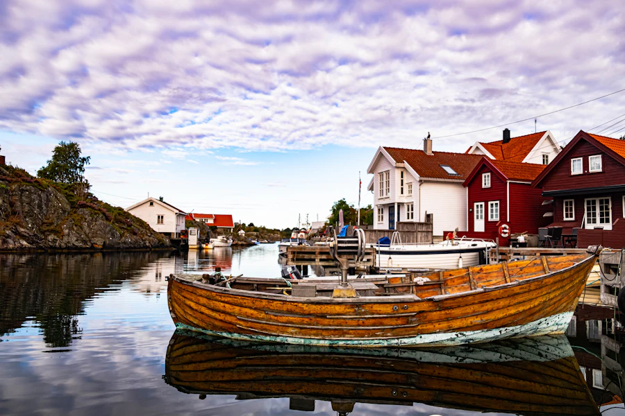 Wooden boat and red harbor house in Kristiansand, Norway