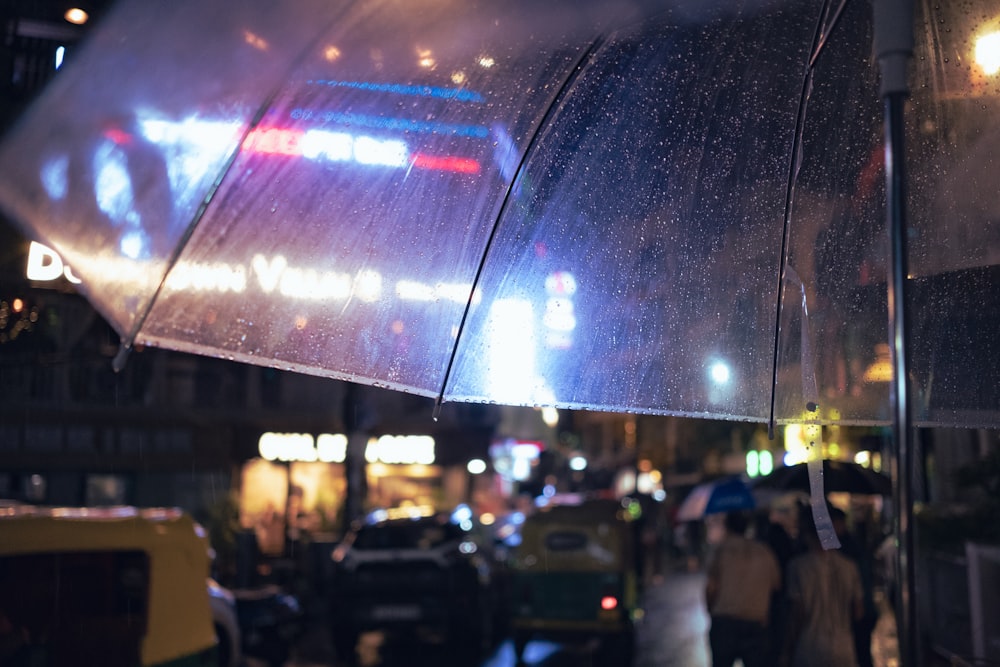 a group of people walking under a large umbrella