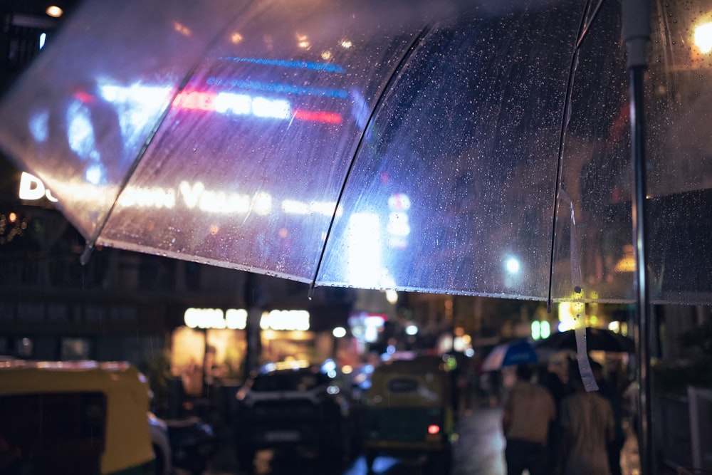 un groupe de personnes marchant sous un grand parapluie