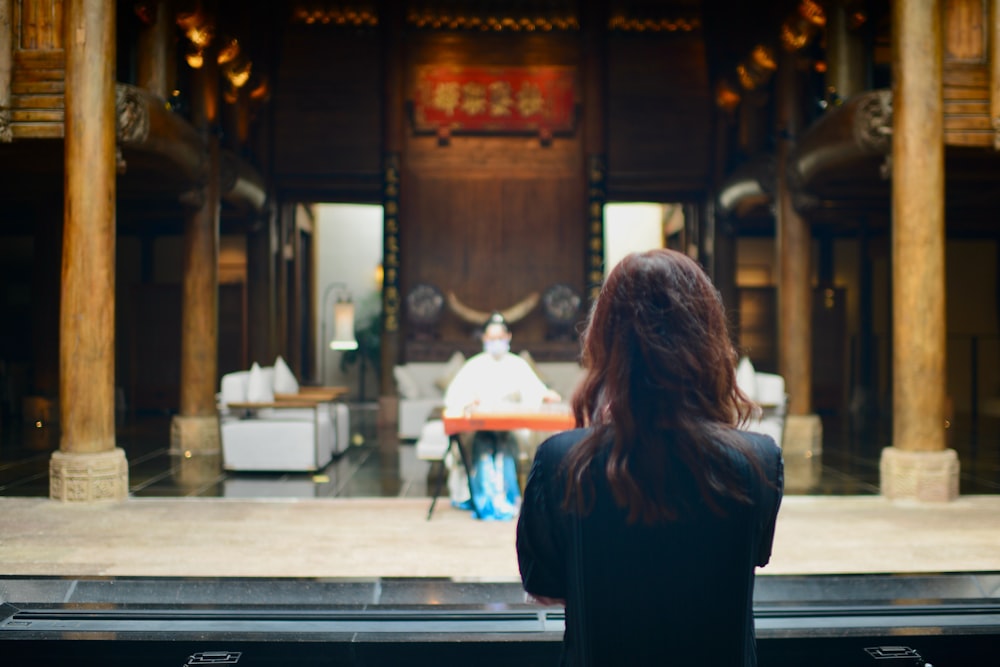 a woman sitting in front of a shrine