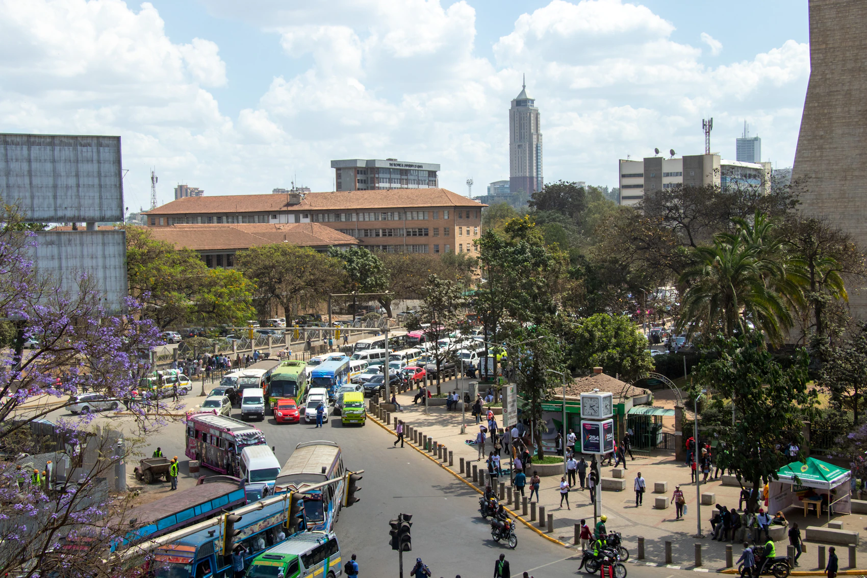 Traffic, buses and pedestrians moving through central Nairobi beneath the skyline