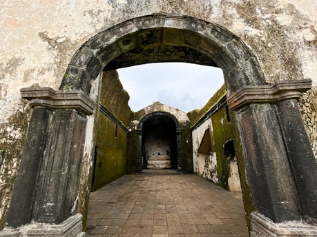 a stone walkway with arched doorways