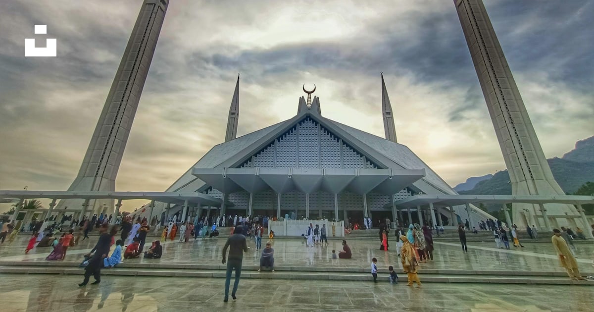 ファイサルモスクを背景にしたガラス張りの大きな建物の写真 Unsplashの無料夕方の空写真