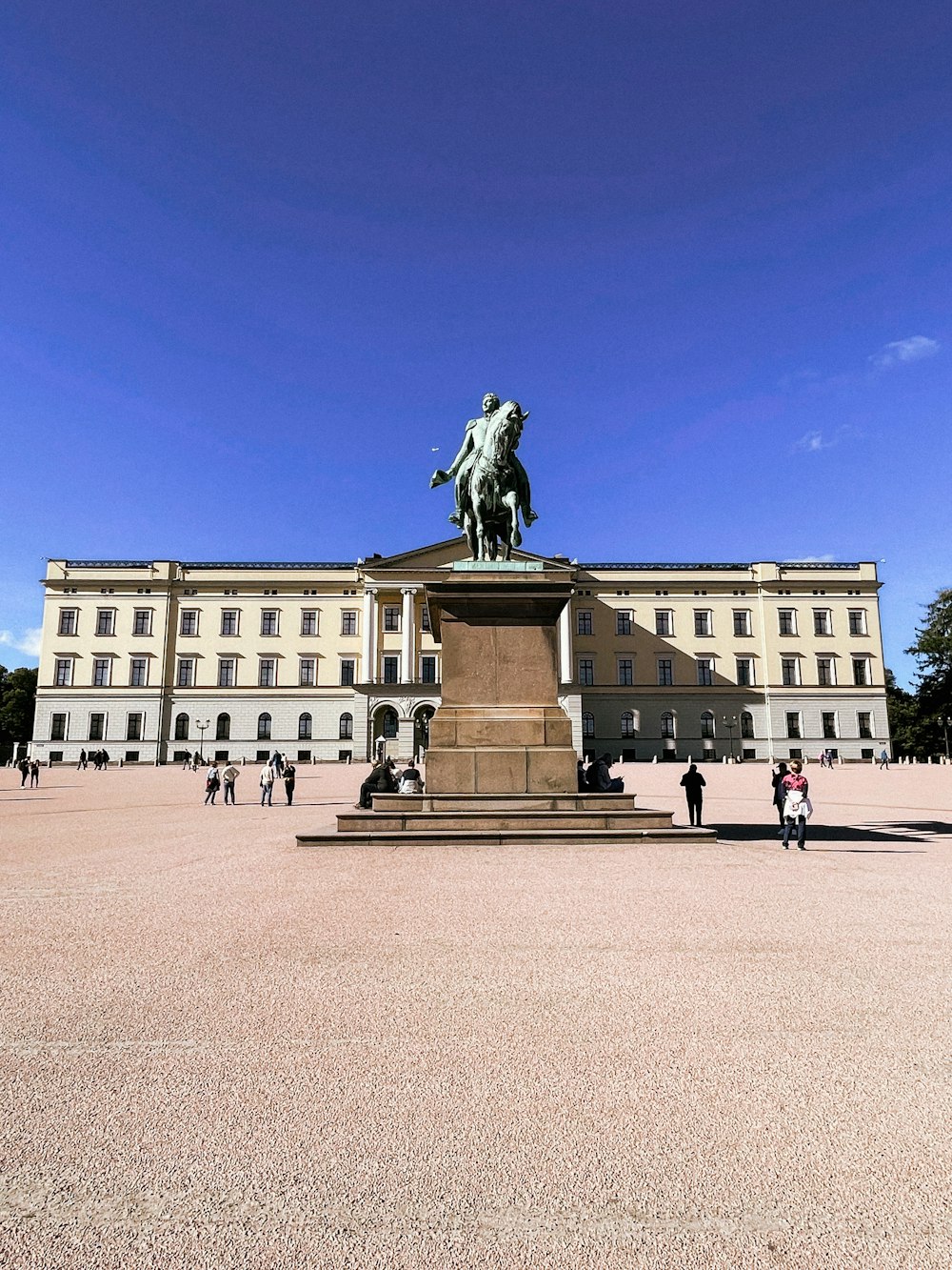 a statue of a person on a horse in front of a building