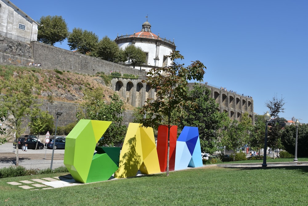 a group of tents in a grassy area with a building in the background