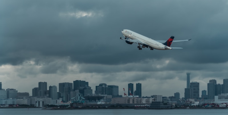 A commercial airliner flying low over a city skyline, the kind of approach path that drives FAA height review near Harry Reid International Airport