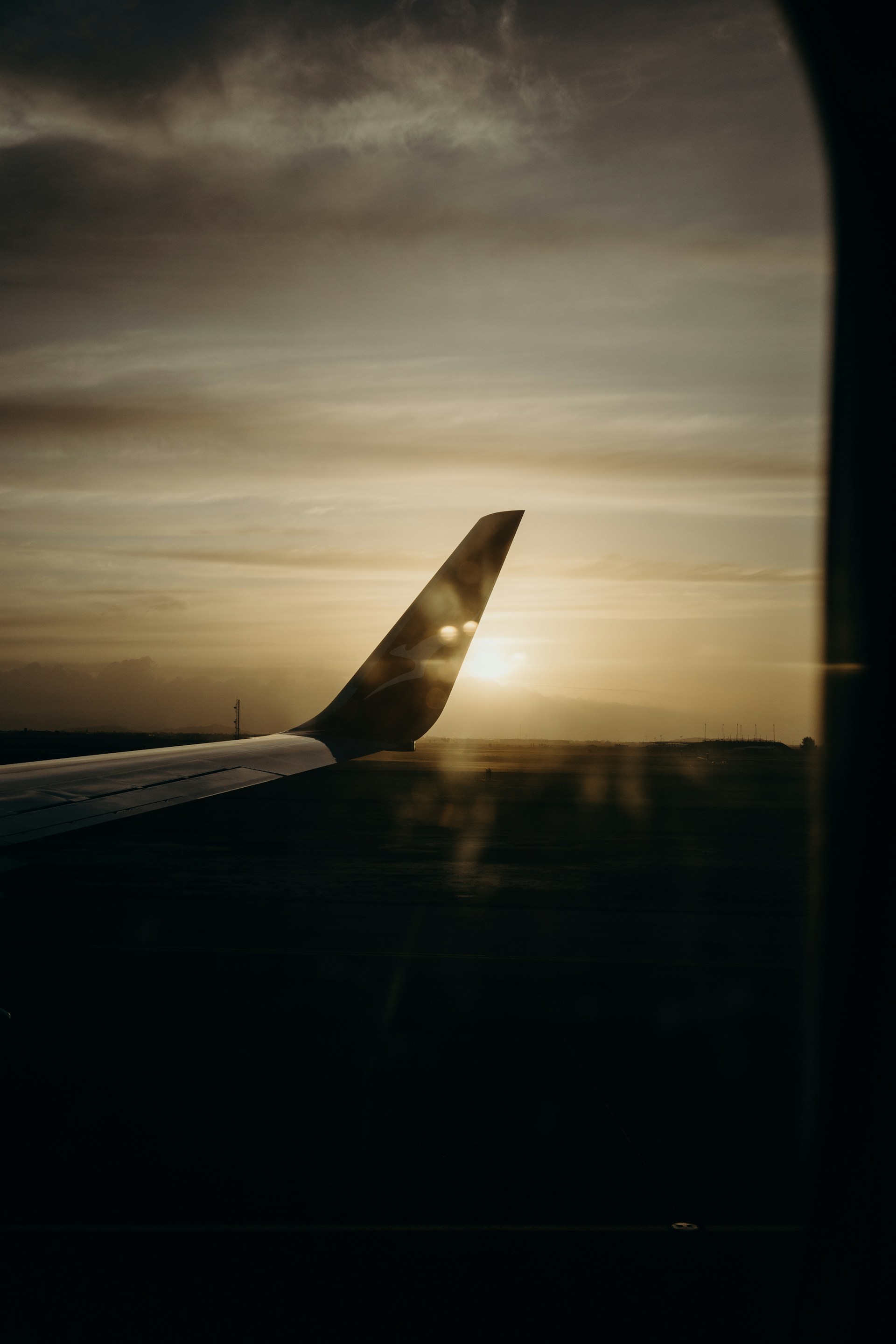 A scenic sunset view from an airplane window, capturing the excitement of budget-friendly adventures.