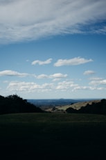 a grassy field with mountains in the background