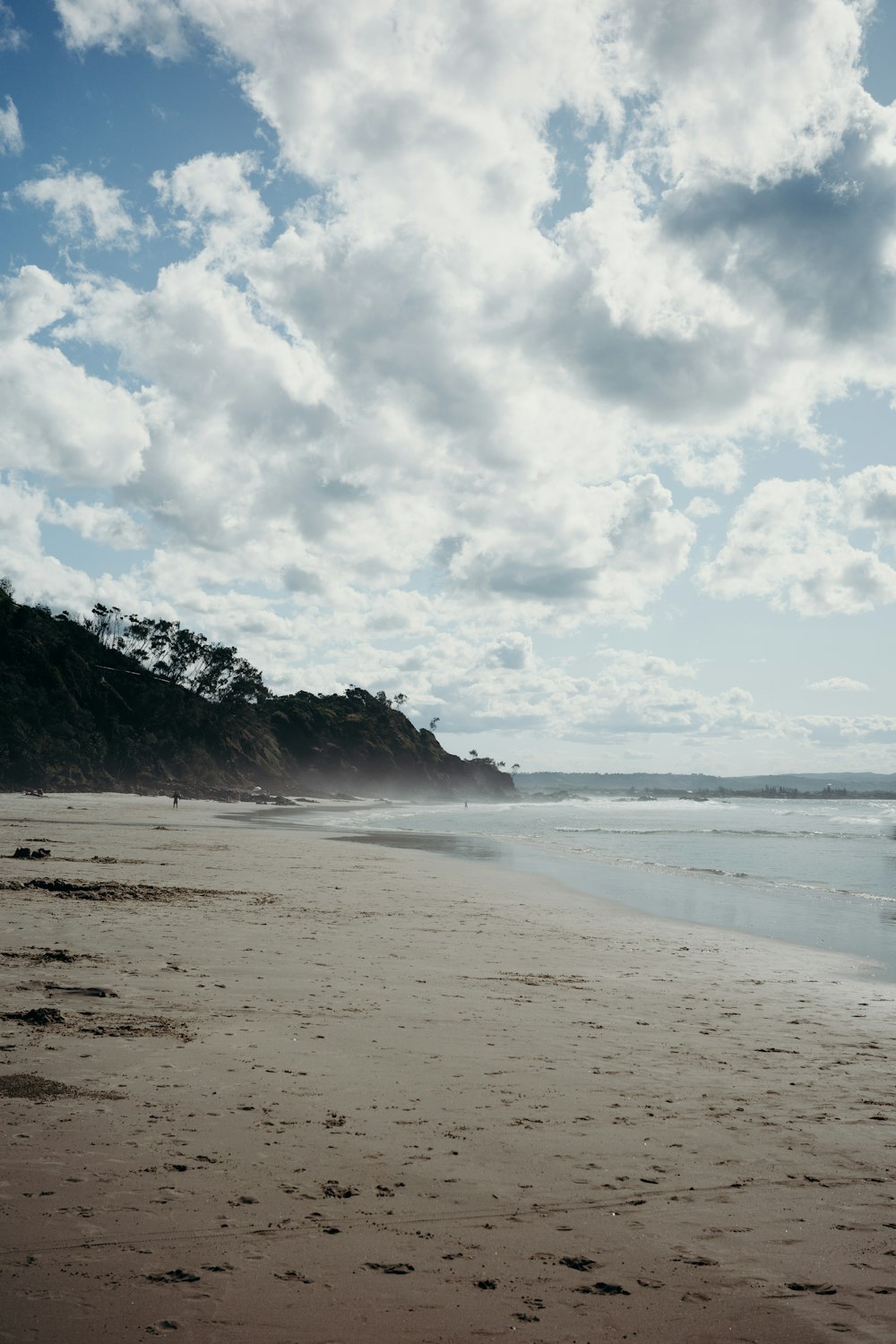 Una playa con una colina al fondo