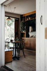 A round café table made of light wood, perfect for small groups.
