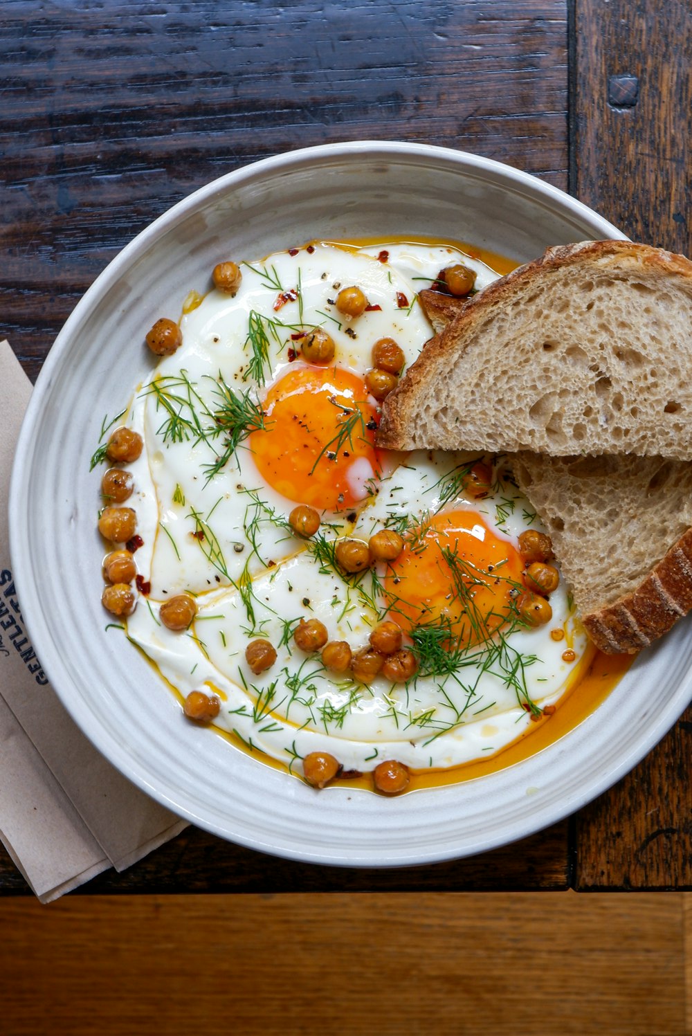 a bowl of soup with bread and a slice of bread