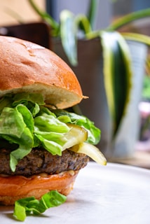 A vibrant close-up of a colorful vegan burger stacked with fresh lettuce, tomato, and a hearty plant-based patty.